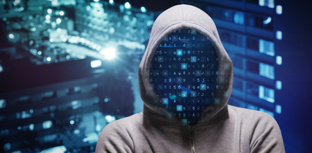 Hacker standing with arms crossed  against high angle view of crowded buildings in city