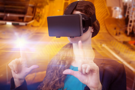 Young woman using virtual reality simulator over white background against illuminated road in cityの写真素材