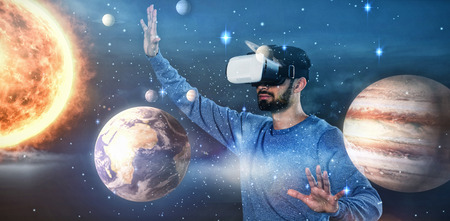 Composite image of solar system against white background against man moving hands while playing vr