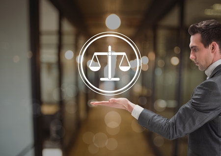 Digital composite of businessman holding justice icon