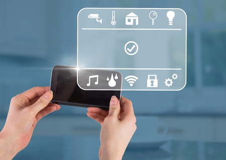 Digital composite of Hand holding phone with smart home interface at homeの写真素材