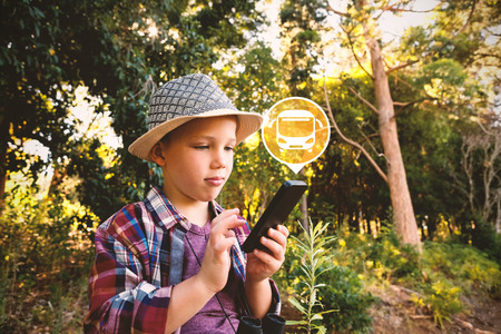 Digital composite image of bus icon on green circle against boy using walkie talkie iat forestの写真素材
