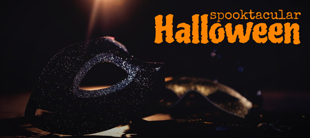 Graphic image of spooktacular Halloween text against masquerade masks on stageの写真素材