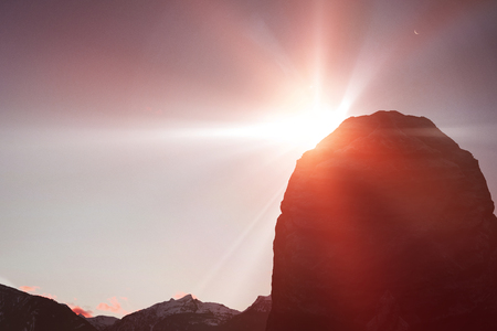 Cropped image of rocky mountain against snowcapped mountains against skyの写真素材