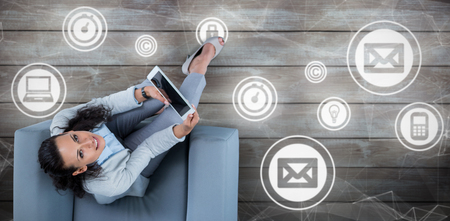 Woman on her tablet looking up against woodの写真素材