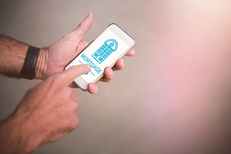Graphic image of icon with mortgage text against cropped image of man using phoneの写真素材