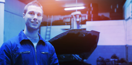Portrait of young male mechanic with digital tablet at garageの写真素材