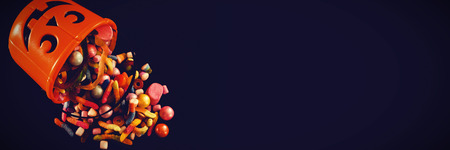 High angle view of bucket with various sweet food over black backgroundの写真素材