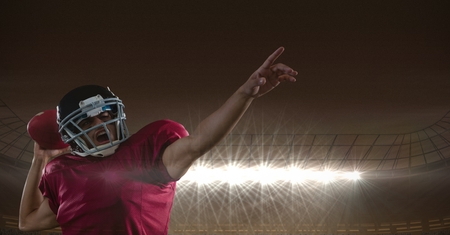 Digital composite of american football  player standing in stadium throwing the ballの写真素材