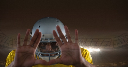Digital composite of american football  player with hands in front of his face