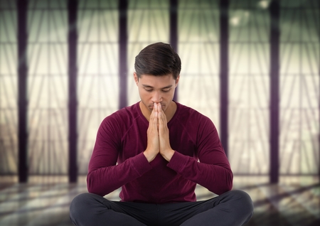 Digital composite of Man meditating in meditation roomの写真素材