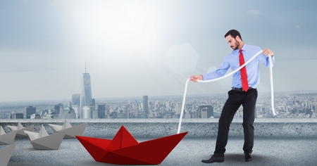 Digital composite of Man with rope pulling 3d paper boatの写真素材