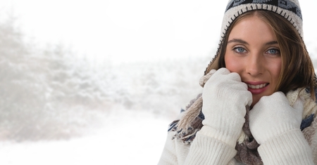 Digital composite of Woman wearing gloves and hat in bright snow forestの写真素材