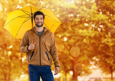 Digital composite of Man in Autumn with umbrella in forestの写真素材