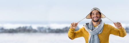 Digital composite of Man with warm hat and scarf in snow landscapeの写真素材