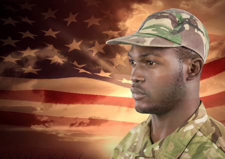 Digital composite of veterans day soldier in front of flagの写真素材