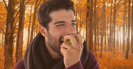 Digital composite of Man in Autumn eating apple in forestの写真素材