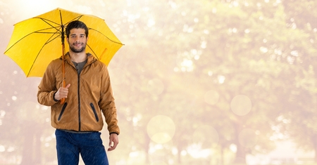 Digital composite of Man in Autumn with umbrella in bright forestの写真素材