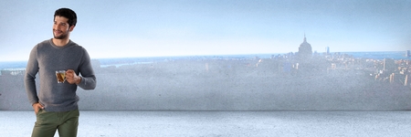 Digital composite of Man holding cup next to smooth city wall