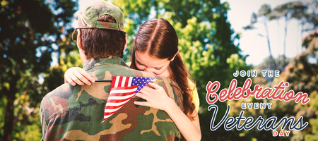 Daughter embracing father against for veterans day in americaの写真素材
