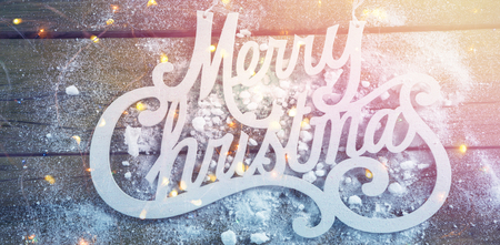 Merry Christmas text with artificial snow on wooden tableの写真素材