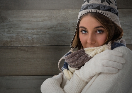 Digital composite of Woman against wood with warm hat and scarf and glovesの写真素材