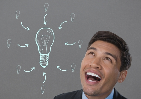 Digital composite of man looking up at light bulb ideaの写真素材
