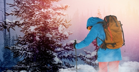 Digital composite of Man standing with skies in snow Forrestの写真素材