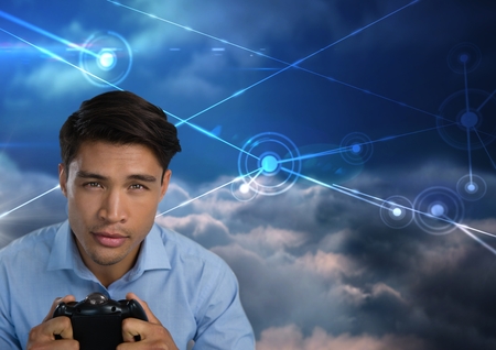 Digital composite of Businessman playing with computer game controller with sky connections backgroundの写真素材