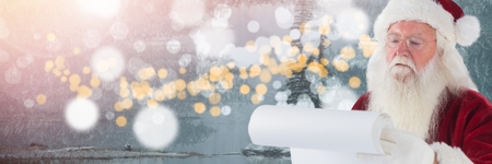 Digital composite of Santa with Winter landscape reading listの写真素材