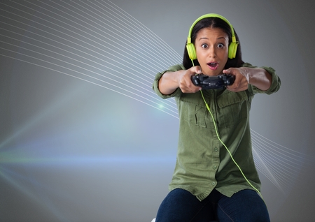 Digital composite of Businesswoman playing with computer game controller with grey backgroundの写真素材