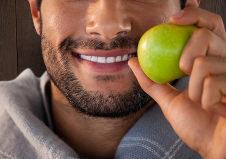 Digital composite of Man against wood with apple and scarf