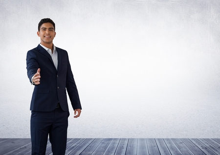 Digital composite of Businessman reaching for handshake in roomの写真素材