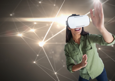 Digital composite of woman playing with virtual reality headset with light connections background