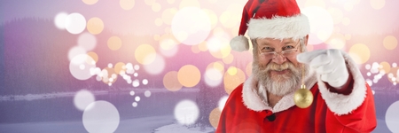 Digital composite of Santa with decoration baubleの写真素材