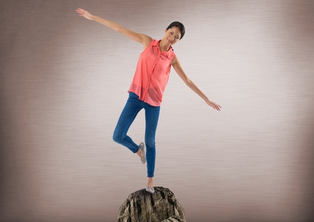 Digital composite of Woman balancing on rock with mystic background