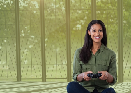 Digital composite of woman playing with computer game controller with nature background