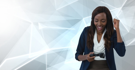 Digital composite of Businesswoman playing with computer game controller with polygon backgroundの写真素材