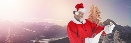 Digital composite of Santa Claus in Winter with listの写真素材