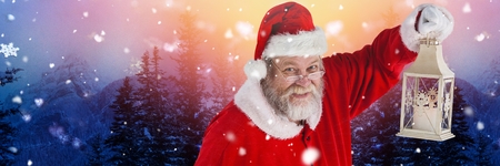 Digital composite of Santa with Winter landscape holding lanternの写真素材