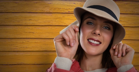Digital composite of Woman against wood with hat