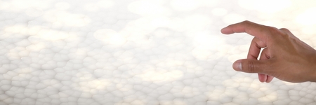 Digital composite of Hand interacting and touching air with bright background