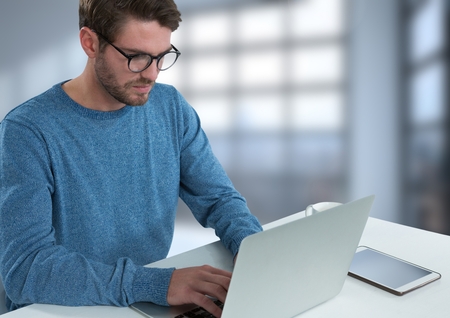 Digital composite of Businessman with laptop at desk with bright background