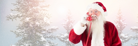 Digital composite of Santa Claus in Winter with phoneの写真素材