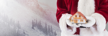 Digital composite of Santa Claus in Winter with home in handsの写真素材