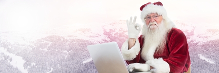 Digital composite of Santa Claus in Winter with laptopの写真素材