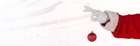 Digital composite of Santa Claus in Winter with Christmas bauble decorationの写真素材