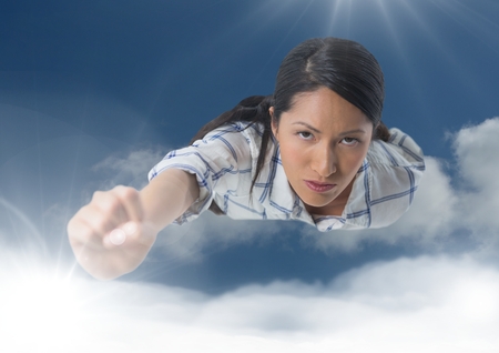 Digital composite of Businesswoman flying in cloudsの写真素材