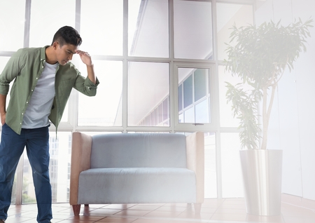 Digital composite of Businessman looking down with chair in waiting room