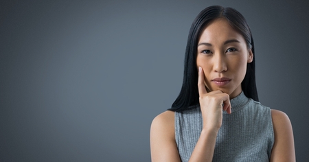 Digital composite of Businesswoman thinking with grey backgroundの写真素材